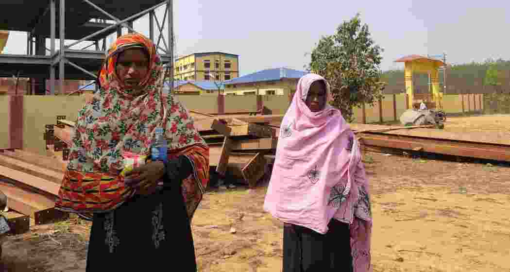 Rohingya refugees pose in front of the foreigner transit camp in Matia, Assam, highlighting their ongoing struggle and demand for relocation.