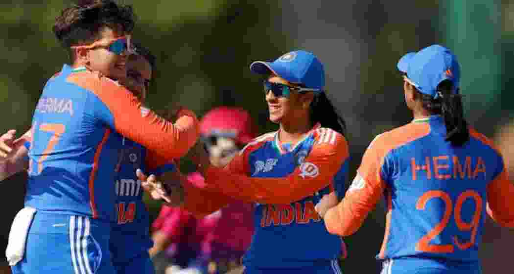 Indian women's cricket team members celebrate a wicket.