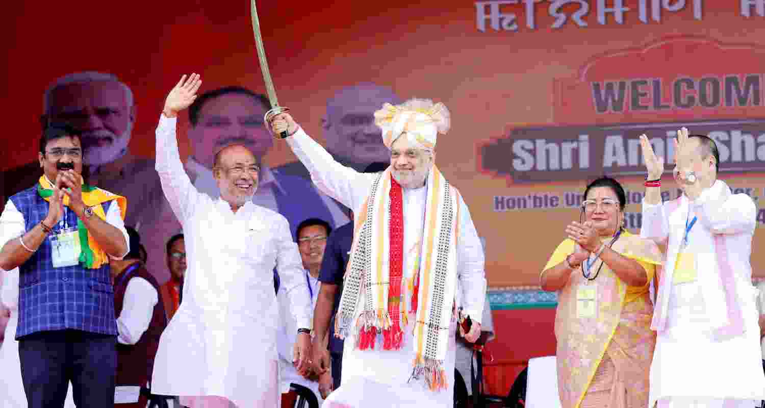 Union Minister and BJP leader Amit Shah holds a sword during a public rally ahead of Lok Sabha polls in Imphal, Manipur on Monday.