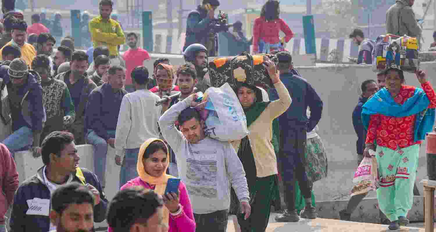 Pedestrians navigating the Singhu border on foot amidst the blockade created by the demonstrating farmers.