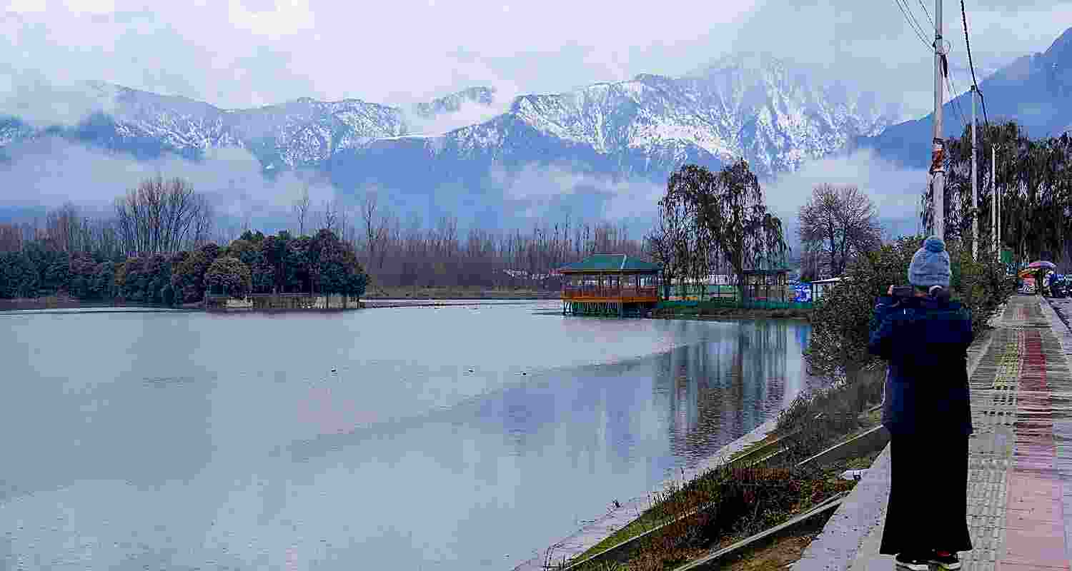 A girl captures moments amidst the rain with her mobile phone in Srinagar.