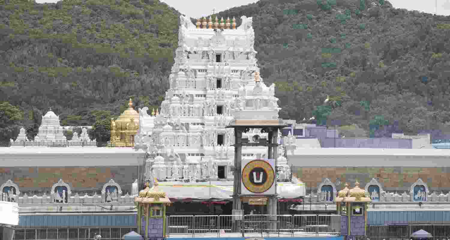 Tirupati Temple in Tirumala, Andhra Pradesh is seen with a crowd of devotees and the backdrop of mountains