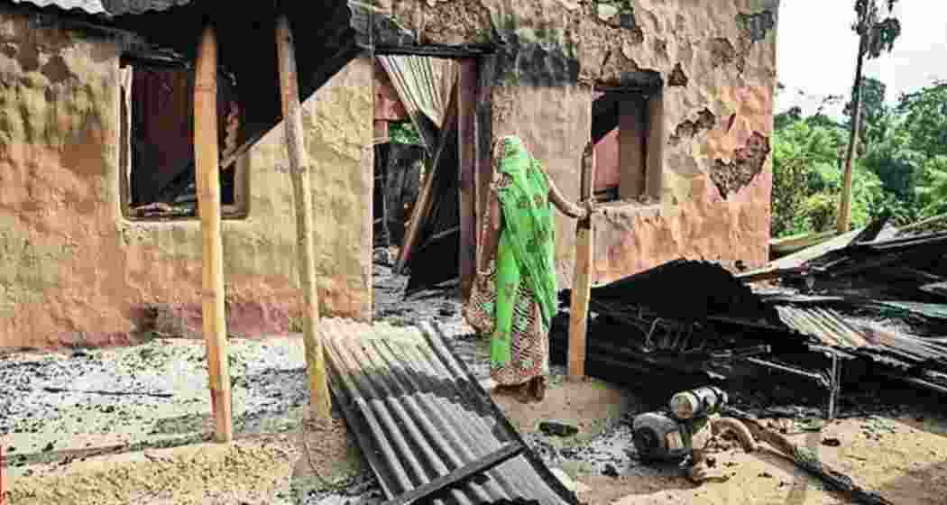 Aggrieved villagers search for belongings in the aftermath of mob violence in Tripura.