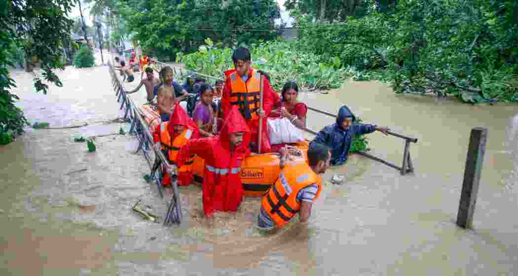 A man carrying his pet dog shifts to a safer place from a flood-affected area following heavy monsoon rainfall, at Adhaynagar village, on the outskirts of Agartala, Thursday, Aug. 22, 2024. 