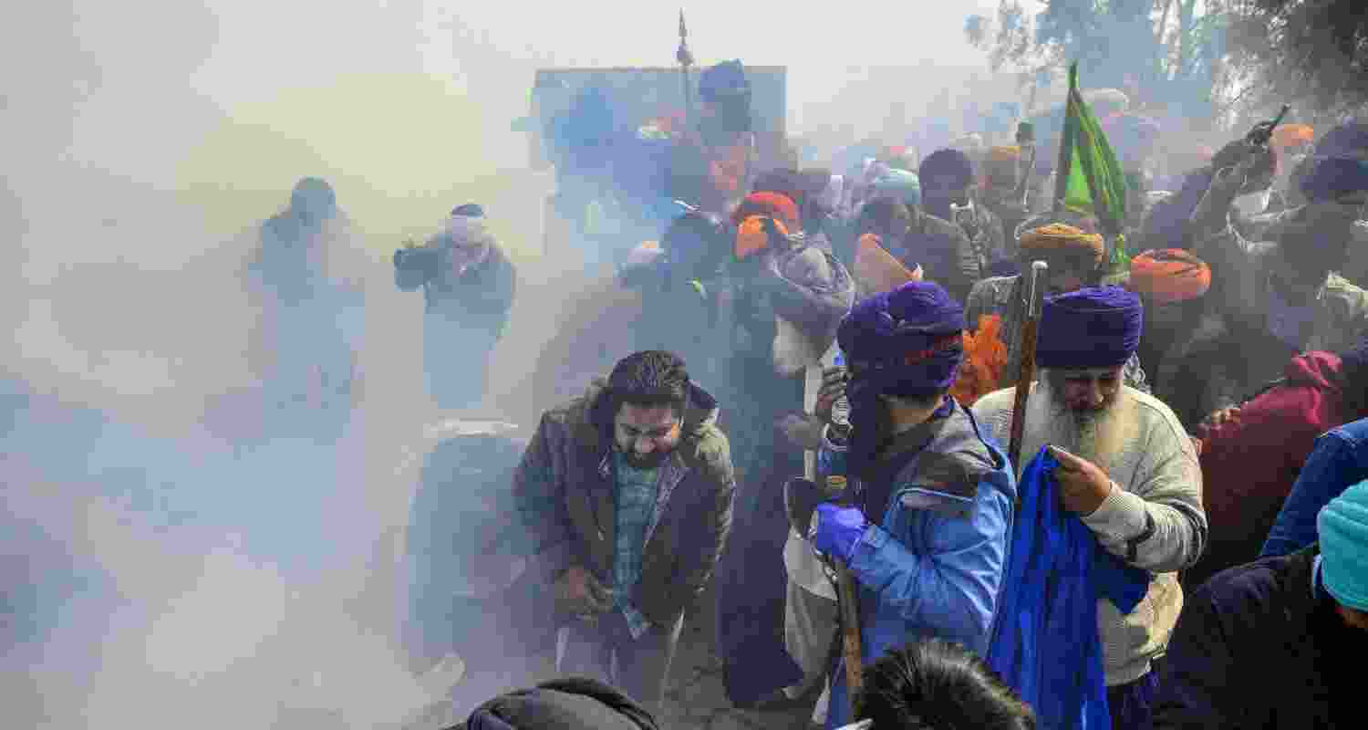 Farmers looking for cover as Police fired tear gas while 'Delhi Chalo' march.