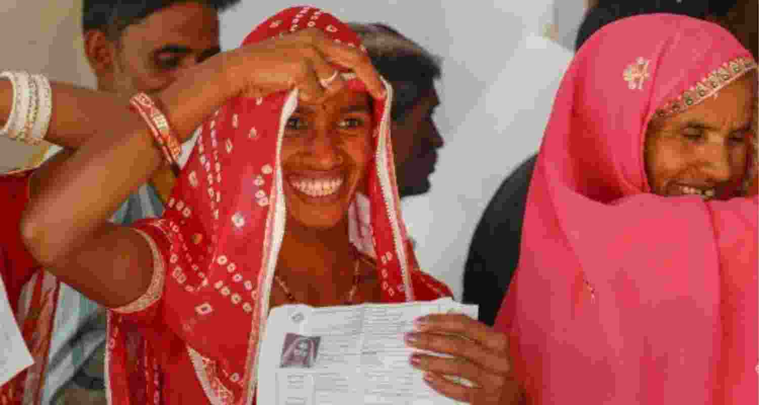 Voter smiles while casting vote.