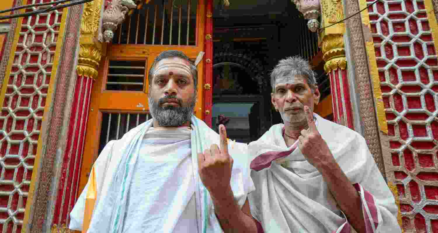 Voters showing inked fingers after casting vote. 