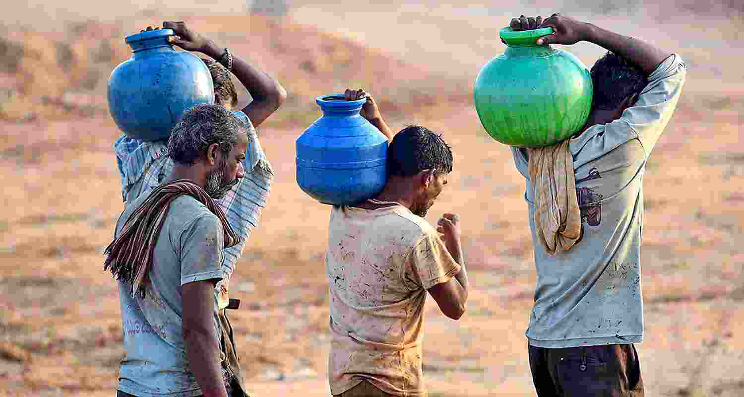 Residents carry pots after collecting drinking water amidst ongoing water crisis, in Chikkamagaluru