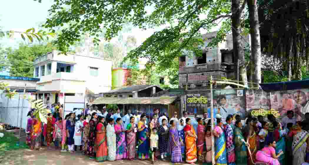 People stand in a queue waiting for their turn to vote at a polling station in West Bengal's Bankura district.