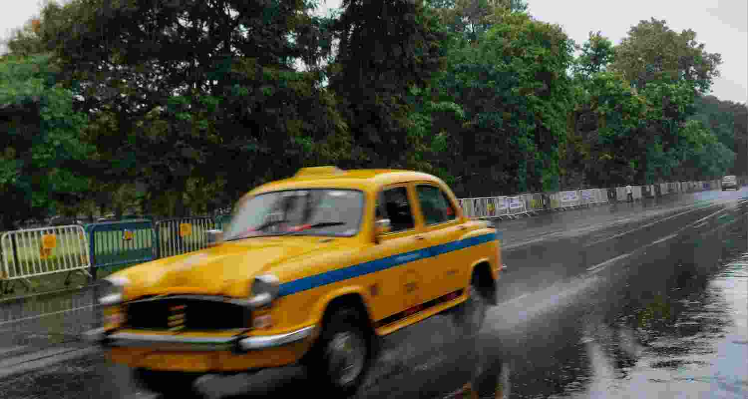 A yellow cab speeds by after rains in Kolkata. Via Unsplash.