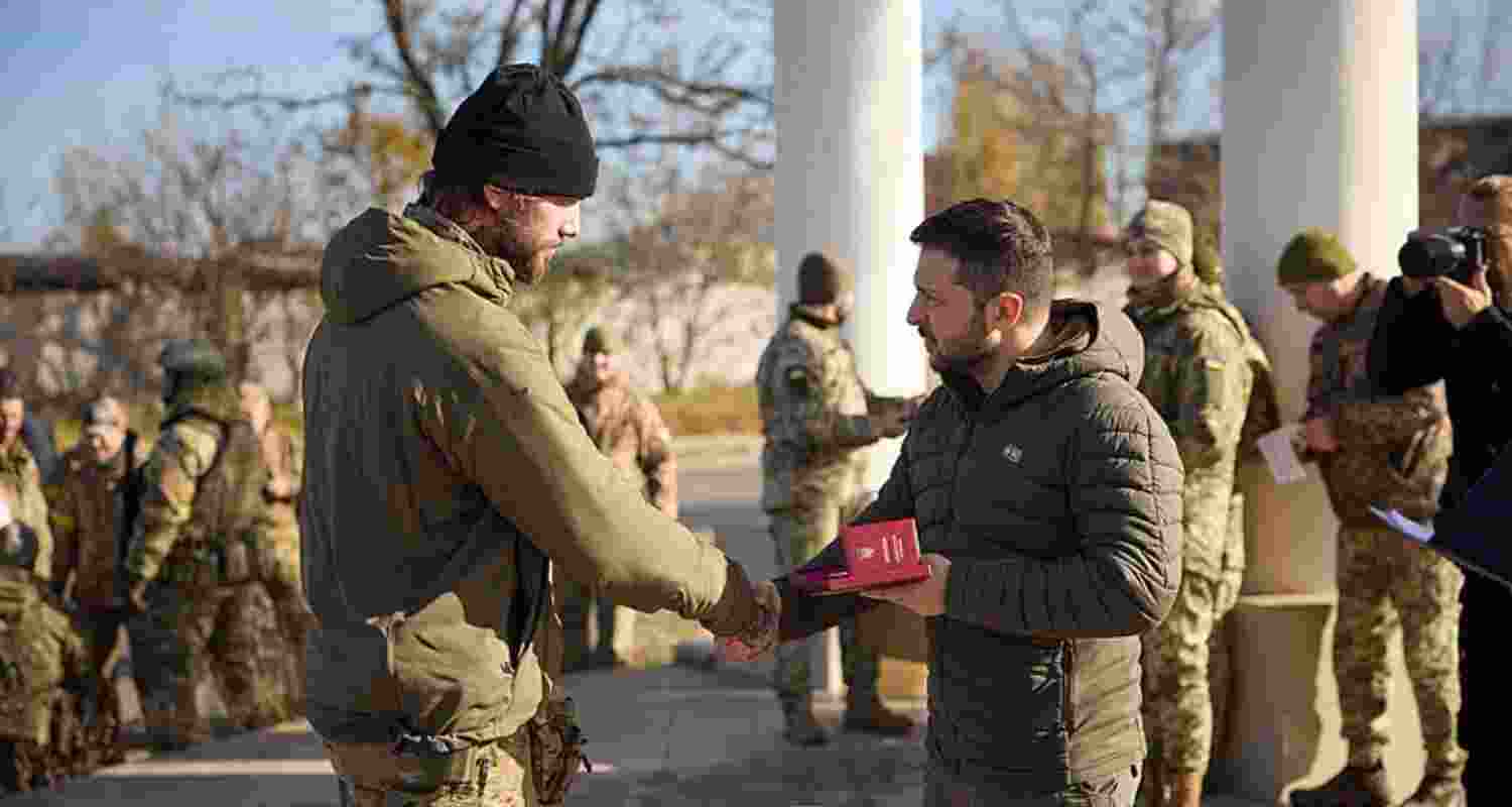 Voldymyr Zelensky meets a soldier in Kyiv where the Russia Ukraine war has left the city damaged, thousands have been killed

