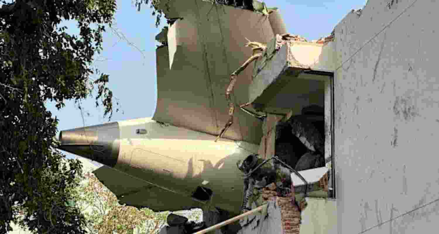 The tail of the Air India plane that crashed shortly after take-off can been seen protruding from the side of a building in Ahmedabad. 