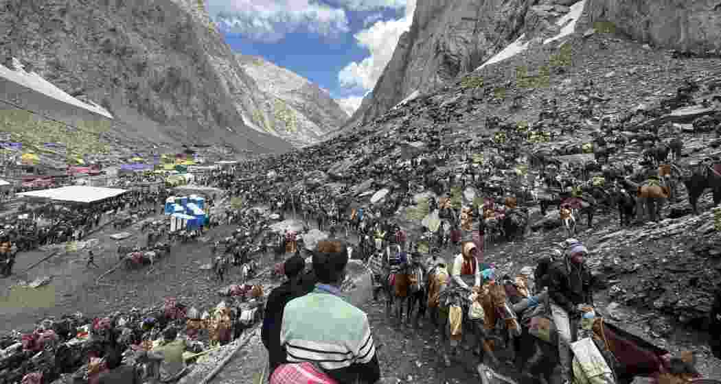 Pilgrims on horseback make their way through the rugged Himalayan terrain towards the sacred Amarnath cave to offer prayers before the naturally formed iced Shivalinga.