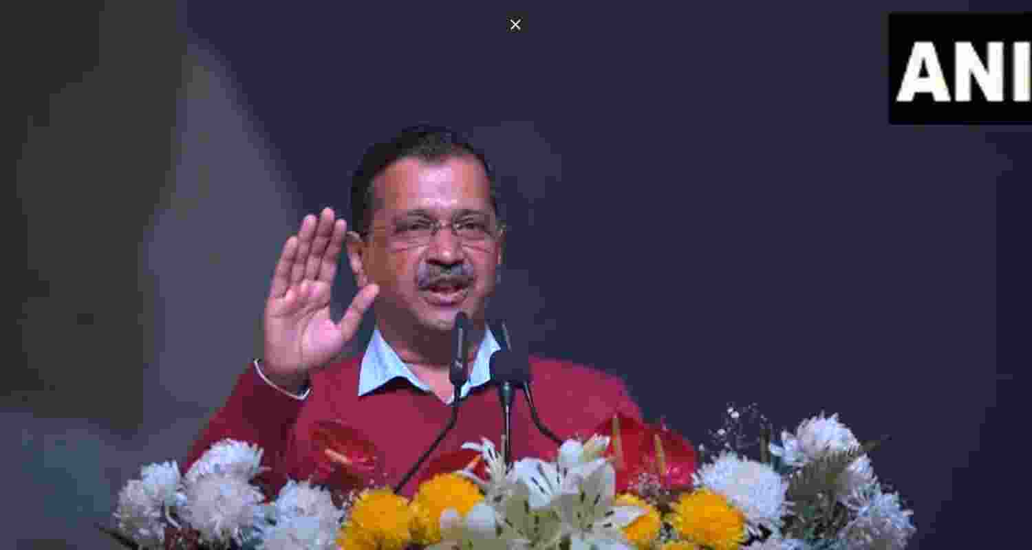 Arvind Kejriwal Delhi Chief Minister wearing a red sweater while speaking to people at a public rally