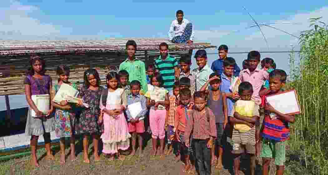 Students stand in front of a “floating school” in Assam. (Photo: Utpal Parashar)
