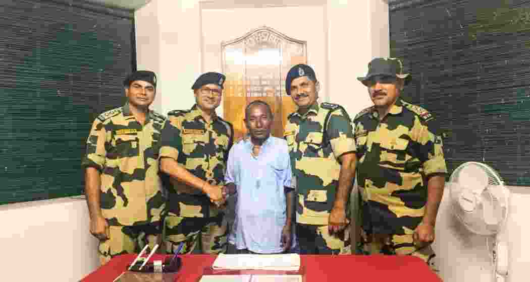 Chandrakant Barman, a North Bengal farmer, with BSF officials, including North Bengal Inspector General Rajesh Kumar Yadav, at Shitalkuchi police station in Cooch Behar, after his return from Bangladesh.