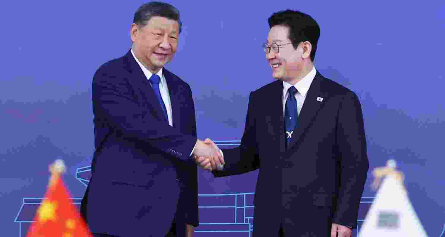 Chinese President Xi Jinping (left) shakes hands with South Korean President Lee Jae Myung. 