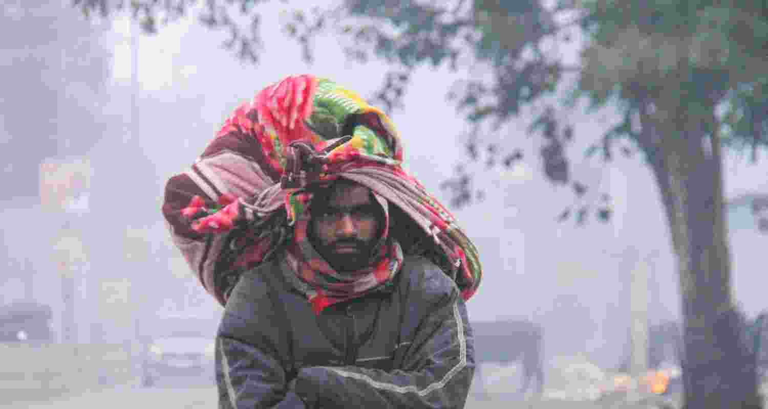 A pedestrian on a cold and foggy winter morning, in Gurugram, Monday. 