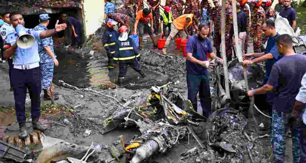 Bangladesh's fire service and security personnel conduct a search and rescue operation at the crash site.