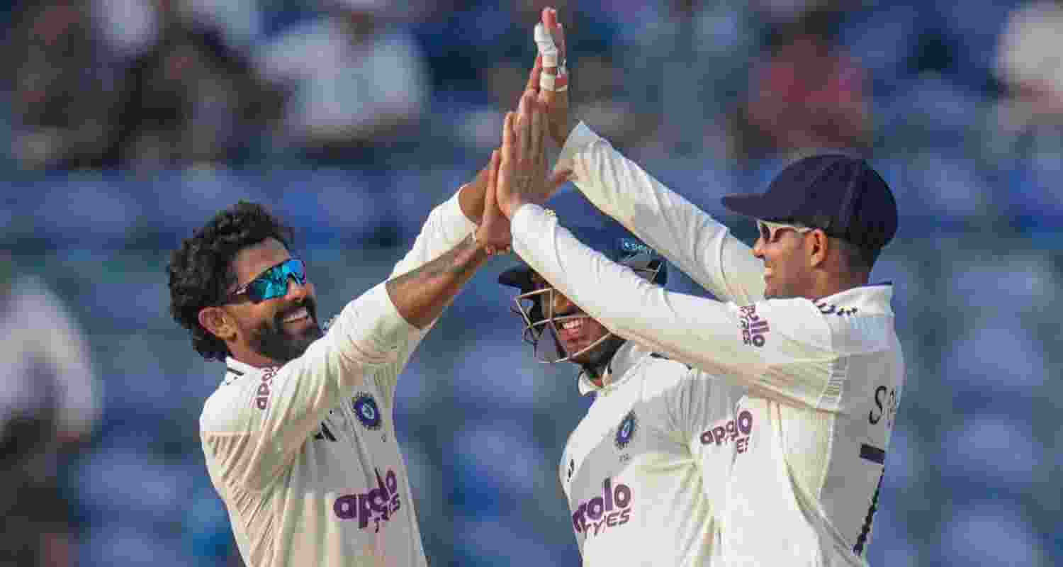 Ravindra Jadeja celebrates with captain Shubman Gill after taking the wicket of West Indies captain Roston Chase in New Delhi on Saturday.