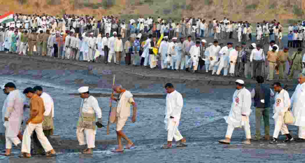 Gandhian followers march along the banks of the Mahai River at Karali village, 140 km south of Ahmedabad, on March 20, 2005, marking the 75th anniversary of the Dandi Yatra. The 1930 Salt March, led by Mahatma Gandhi, protested British salt laws and ignited a nationwide movement for India's independence.