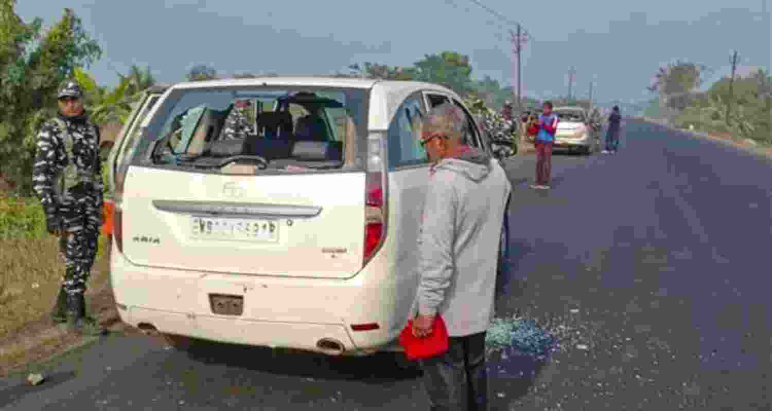 Security personnel with others stand near a vehicle which was allegedly damaged by the supporters of TMC leader during a raid by ED officials, in West Bengal's North 24 Parganas district on January 5.