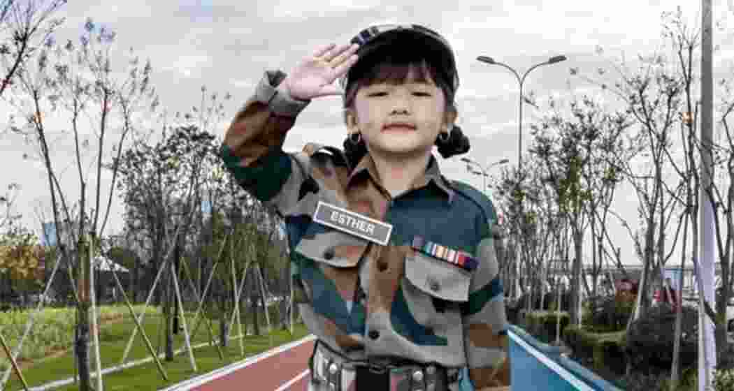 Child singing prodigy Esther Hnamte salutes in an Indian Army uniform.