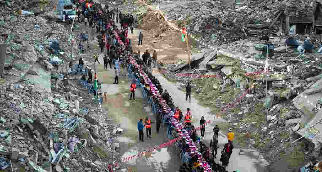 Palestinians sit at a large table surrounded by the rubble of destroyed homes and buildings as they gather for iftar, the fast-breaking meal, on the first day of Ramadan in Rafah, southern Gaza Strip, Saturday, March 1, 2025.