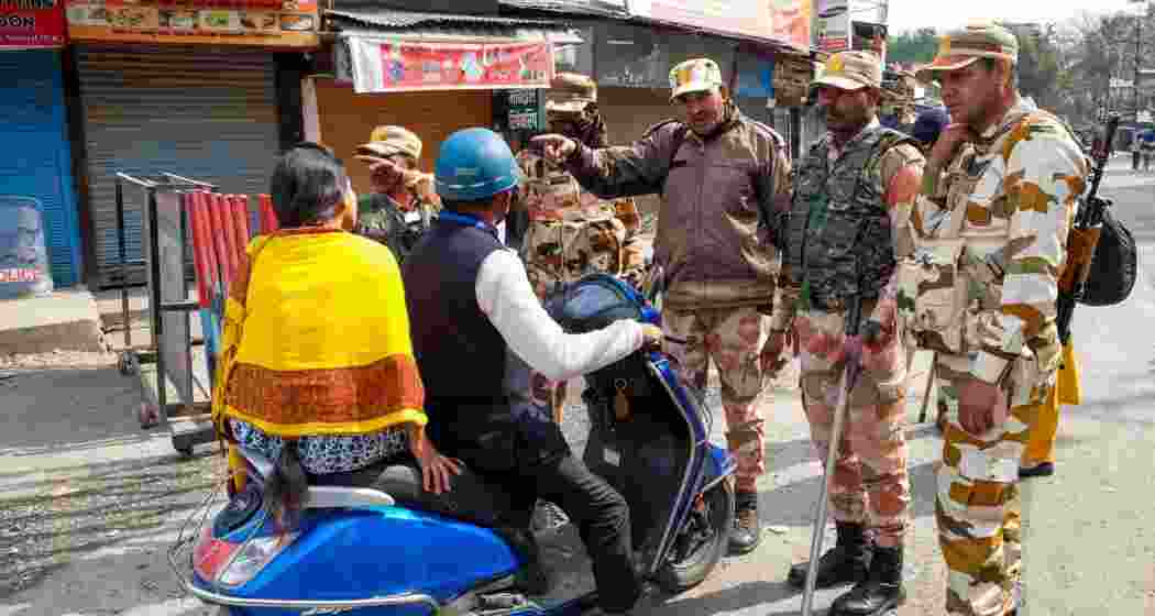Security personnel providing guidance to commuters regarding alternative routes to navigate amidst the aftermath of the violence in Haldwani, Uttarakhand.