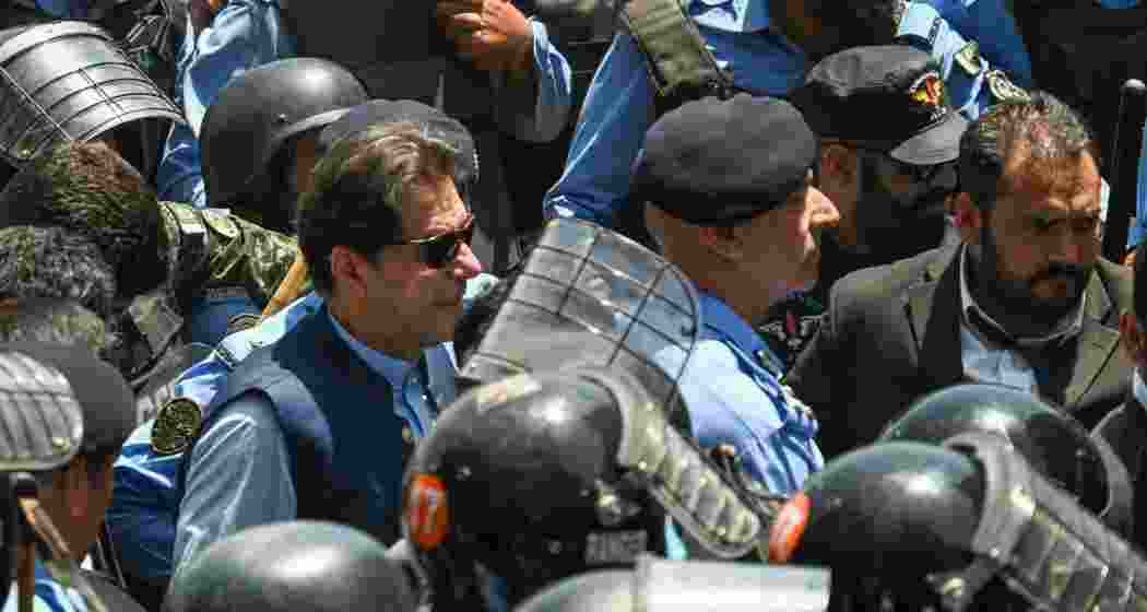 Police escort Pakistan's former Prime Minister Imran Khan upon his arrival at the high court in Islamabad. File photo.