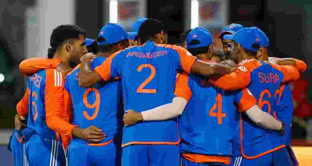 Indian cricket team players gather for a discussion during a match.