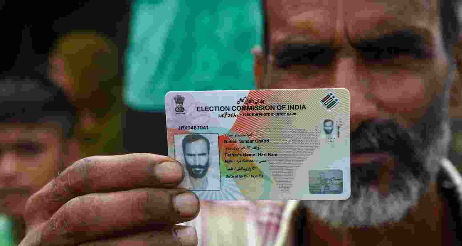 A voter shows his voter ID card during the Jammu and Kashmir polls.