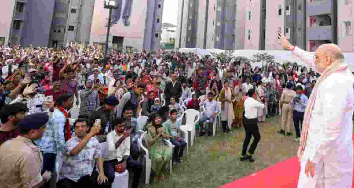 Union Home Minister Amit Shah waves to people during the inauguration of 861 newly constructed EWS houses built under the PM Awas Yojana, in Ahmedabad on Sunday.
