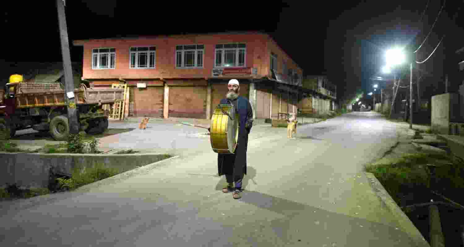 A Kashmiri man 'Sahar Khan' (human alarm) walks through a street to wake up Muslims for pre-dawn meals (Sehri) on the first day of the holy month of Ramzan. Image: X