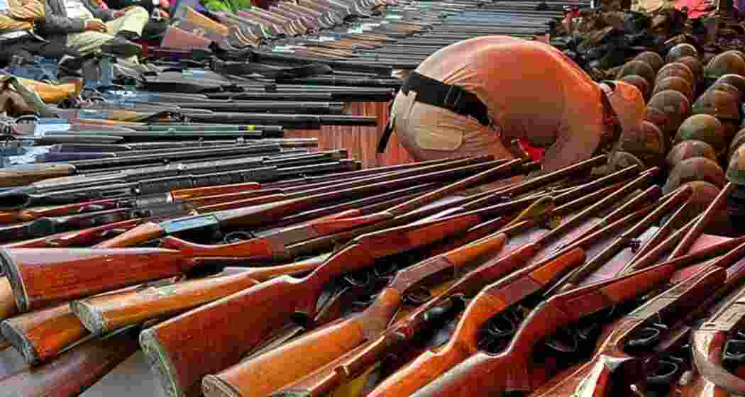 A security personnel inspects firearms surrendered as the deadline extension prompts fresh handovers, in Imphal, Manipur on Friday.