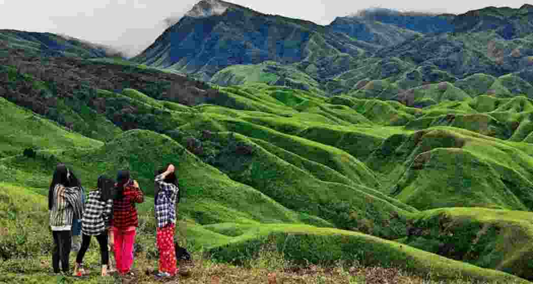 A group of tourists pause to photograph and admire the serene mountains of Manipur.