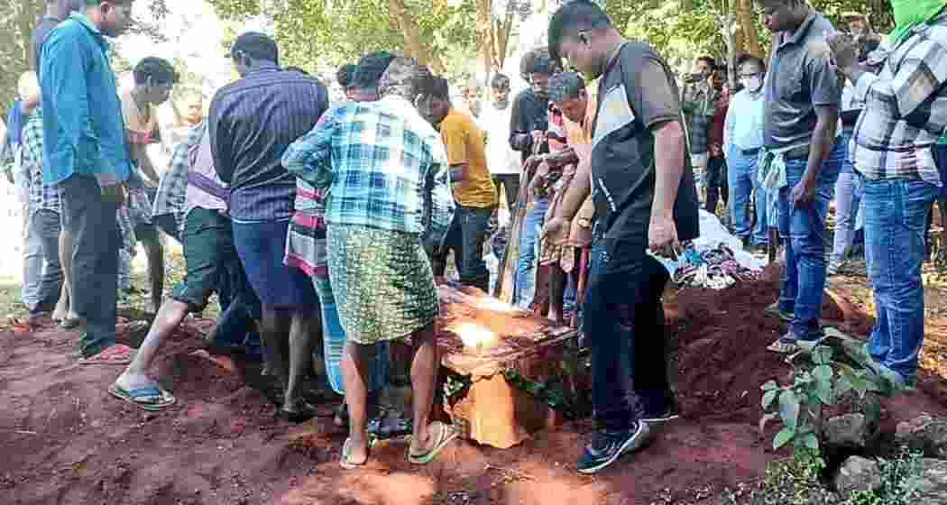 People pull the coffin of the deceased man as his body is exhumed following allegations of suspected organ theft.