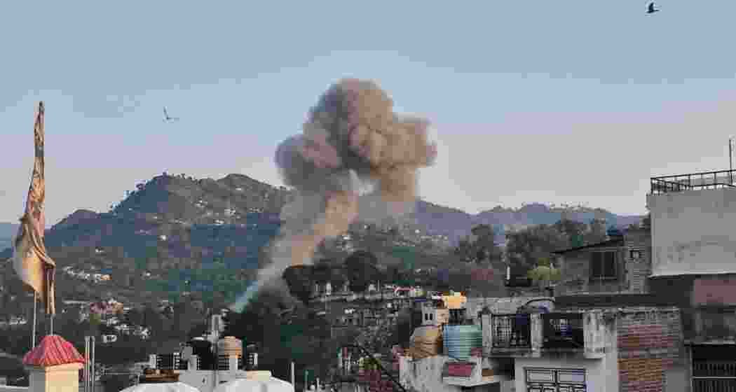 Smoke rises from a residential area in Jammu after intense shelling by Pakistan caused extensive damage to homes and infrastructure. Local officials have urged residents to remain vigilant amid ongoing cross-border attacks.