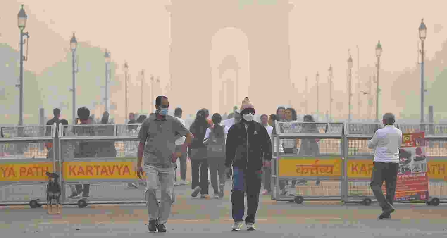 Visitors at the Kartavya Path near the India Gate amid smog, in New Delhi, Saturday. 