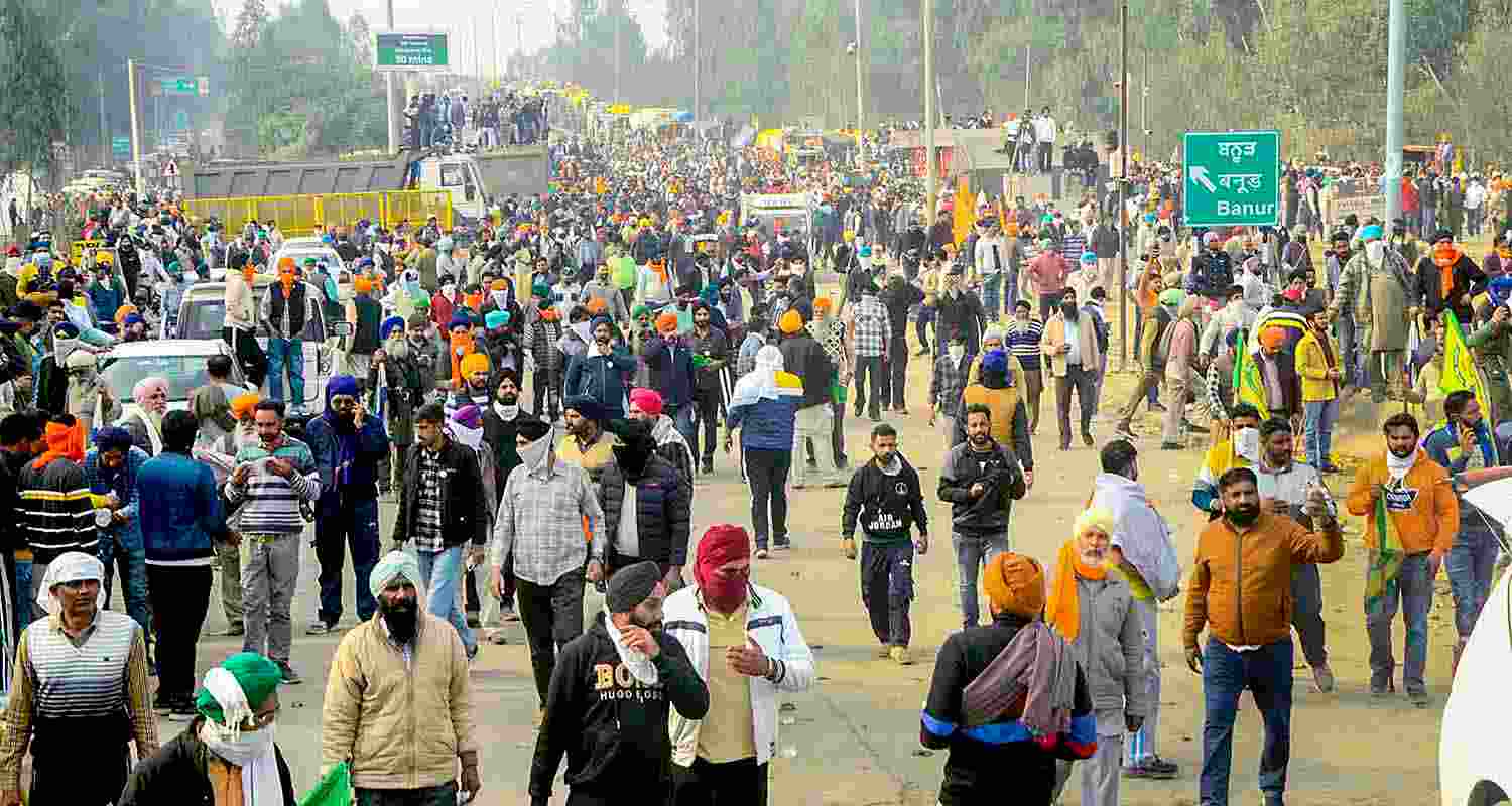 Farmers move away after police fired teargas shell to disperse them during their 'Delhi Chalo' march at Punjab-Haryana Shambhu border, near Patiala, Tuesday. 