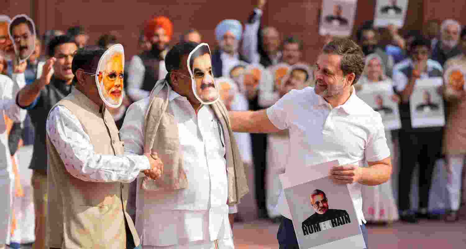 Leader of Opposition in the Lok Sabha Rahul Gandhi, right, with Congress MPs Manickam Tagore and Saptagiri Sankar Ulaka, wearing face masks of Prime Minister Narendra Modi and Adani Group Chairman Gautam Adani, at a protest demanding a probe into the bribery case in the US involving the billionaire industrialist during the Winter session of Parliament, in New Delhi, Monday.