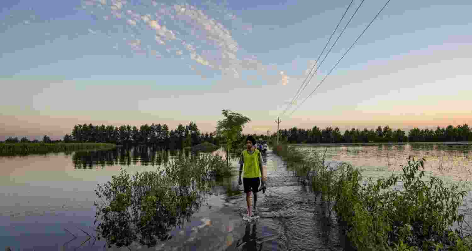 A man walks through a flooded area in Talwandi Rai Dadu village of Ajnala in Amritsar district.