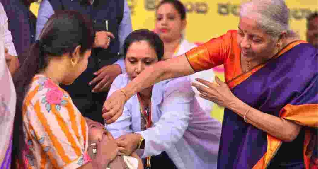 Union Finance Minister Nirmala Sitharaman administers oral polio drops to a child during the statewide pulse polio immunisation drive at Kamalapura in Karnataka on Sunday.