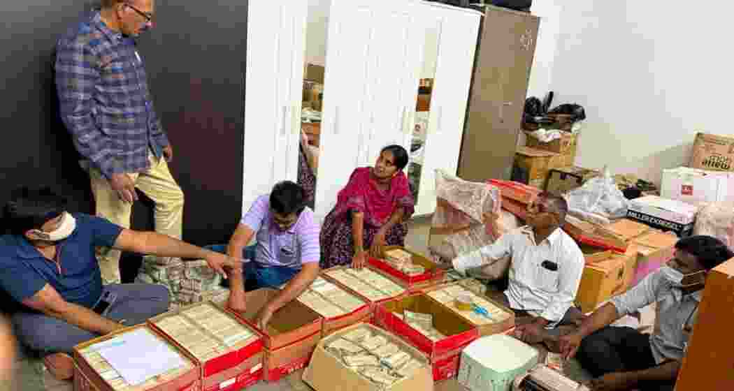 Officials tally bundles of cash seized in a raid at a Shamshabad farmhouse near Hyderabad.