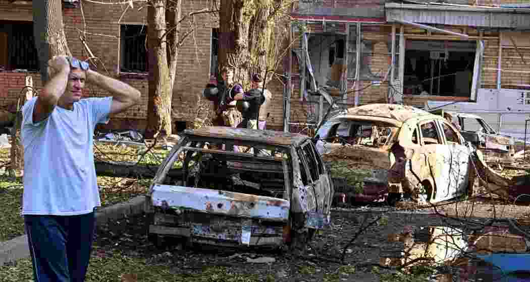 A man stands next to the burnt-out remains of cars in the courtyard of a multi-storey residential building, which, according to local authorities, was struck by an Ukrainian missile during the Russia-Ukraine conflict in Kursk, Russia. File photo.