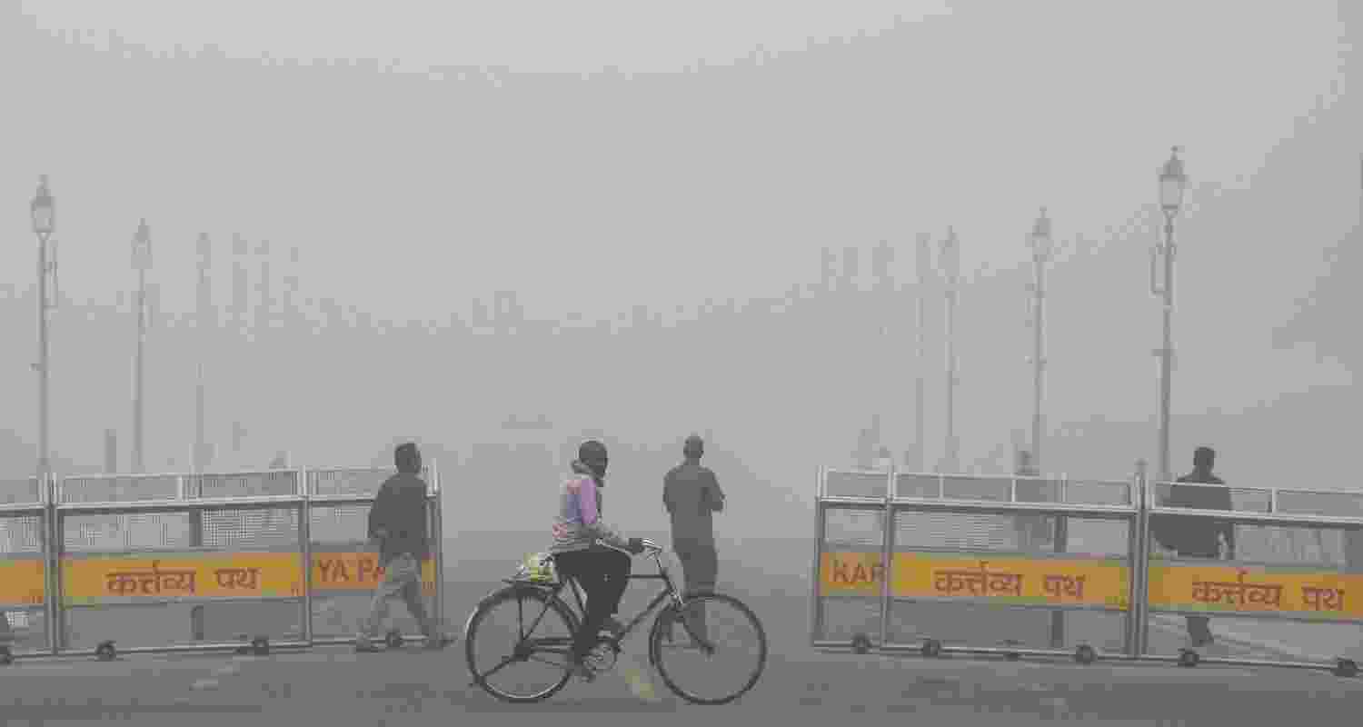 A man cycles near the India Gate amid low visibility due to smog as air quality remains in 'severe' category, in New Delhi, Monday.
