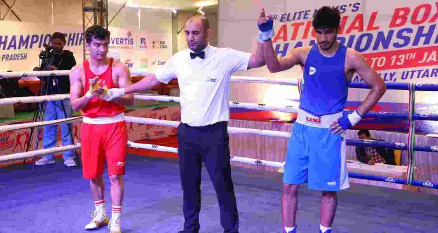 Abhinash Jamwal (in blue) being declared as the winner in the 65 kg bout.