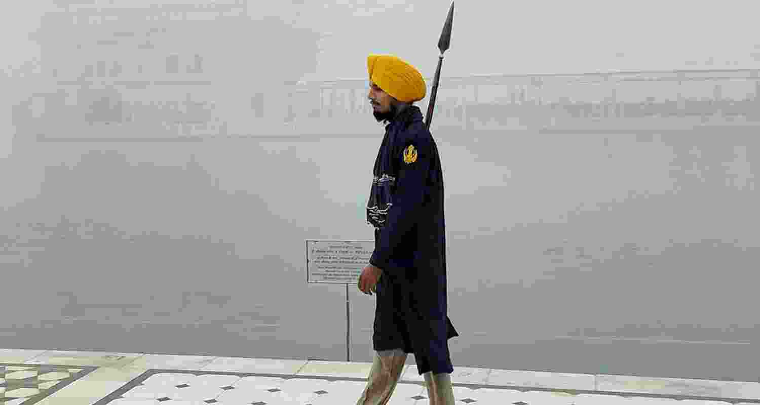 A devotee visits the Golden Temple amid a thick layer of smog as the air quality in the region continues to deteriorate, in Amritsar, Thursday. 
