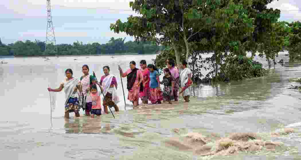 Villagers wade through the flood waters at Dhamdama in Nalbari district of Assam. (File photo)