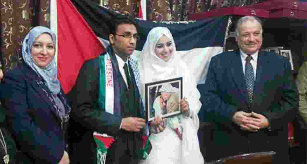 Indian postgraduate scholar at Georgetown University Badar Khan Suri and his wife, Mapheze Saleh, hold an image of Palestinian political leader and Chairman of the Palestine Liberation Organisation, Yasser Arafat kissing Hamas founder Ahmed Yassin at their wedding.